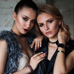 Two stylish women posing together, one in a fur vest and the other in a leather jacket. Dare to dream.