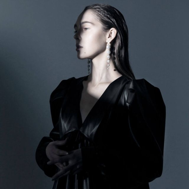 Woman in black satin dress, dreaming.