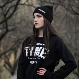 Young woman wearing black WildSlope beanie and sweatshirt, dreaming