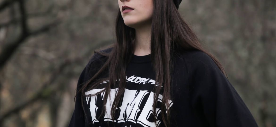 Young woman wearing black WildSlope beanie and sweatshirt, dreaming