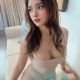 Aiza, a Malaysia escort model, poses in a beige dress.