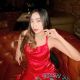 Attractive woman in red dress at a bar. Incall and outcall escort services available.