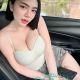 Amilia, a real KL escort girl, smiles in a car.