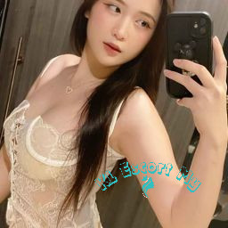 Attractive young woman in a lacy white bodysuit taking a selfie. KL Escort My