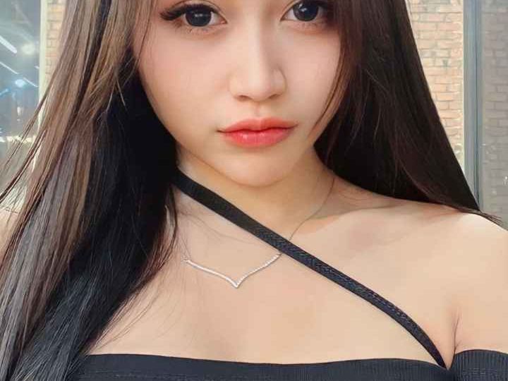 Attractive young woman with long dark hair, wearing a black off-the-shoulder top. KL Escort My